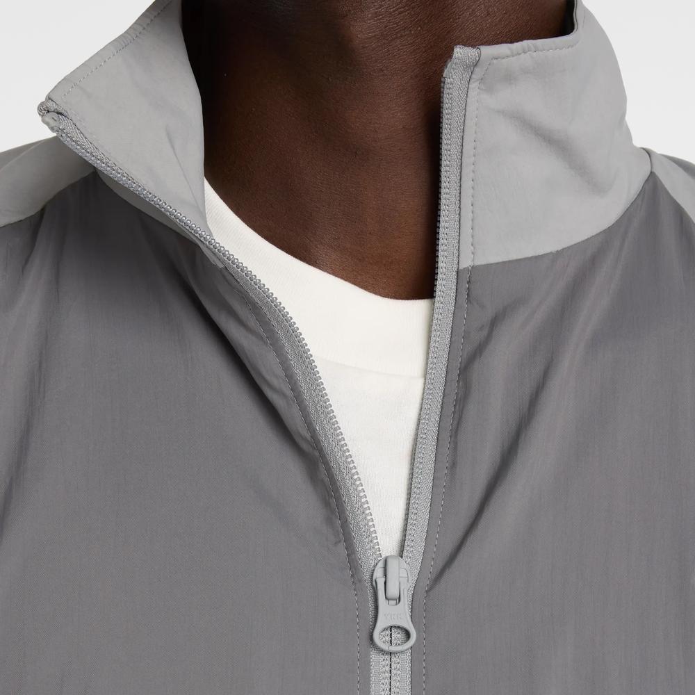 Mužský vetrovka New Balance MJ61J73YCAS - šedý